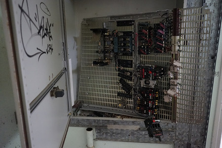 带涂鸦门板的工业电控箱，内部元件暴露