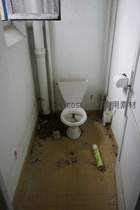 破败厕所角落马桶旁散落废弃纸卷