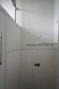 墙角裂缝与脱落瓷砖的浴室一角