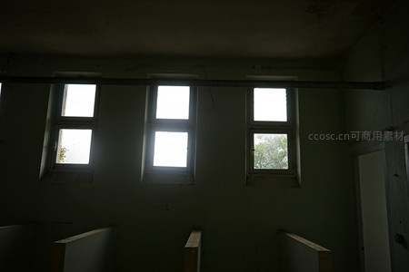 三扇高窗透入微光的废弃房间