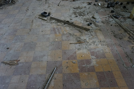 满是尘土与碎片的方格瓷砖地面