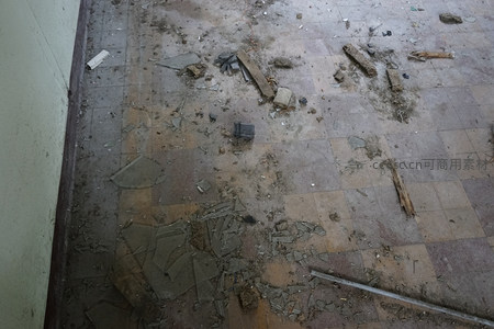 废弃厂房地面散落着碎玻璃与建筑垃圾