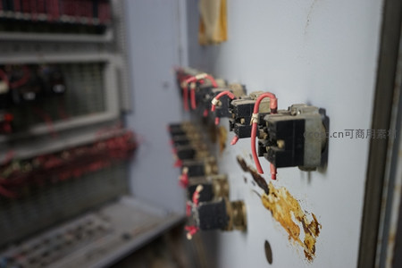 老旧工业控制柜特写，锈迹斑斑的开关与电线