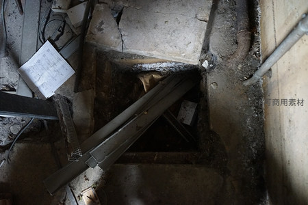 废弃工厂地面破洞与散落杂物特写