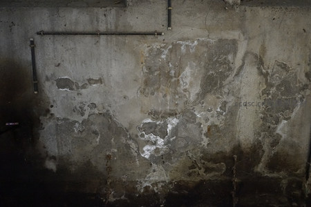 潮湿混凝土墙上的盐碱结晶与管道