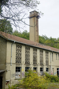 废弃工厂高塔，树木环绕显沧桑