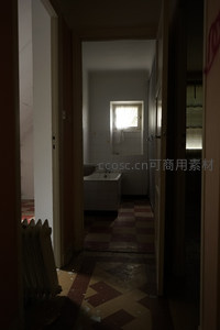 昏暗走廊尽头的浴室与斑驳瓷砖地面