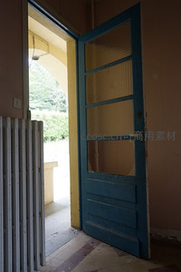 蓝色木门半开，通向室外绿意盎然