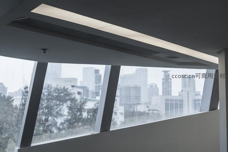 现代建筑窗景，城市天际线隐约可见