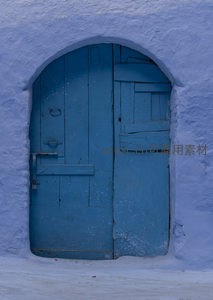 拱形蓝门嵌于白色泥墙中