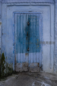 涂鸦与锁具点缀的蓝色老式木门