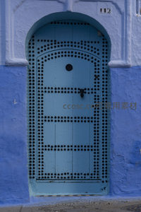 拱形钉饰蓝门与白色边框的经典设计