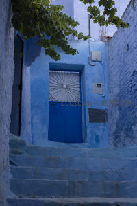 蓝墙小巷中的阶梯与扇形窗