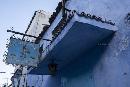 餐厅招牌悬于蓝色阳台之下