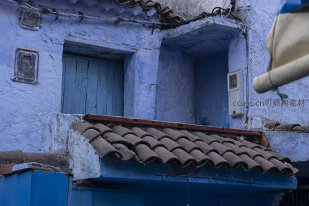 蓝墙斑驳老屋的红瓦窗台