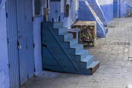 蓝色木梯倚靠在古巷墙角