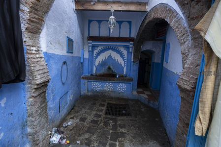 蓝色古城巷道中的传统喷泉