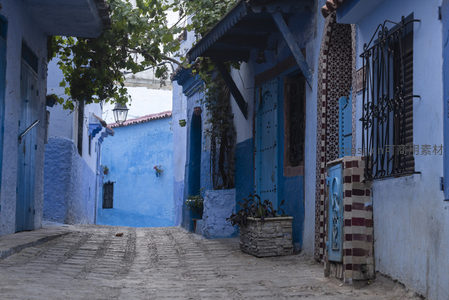 蓝色小镇的宁静巷道，石板路与古朴建筑相映成趣