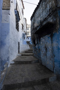 石阶小巷通向远方，蓝色墙壁诉说着岁月痕迹