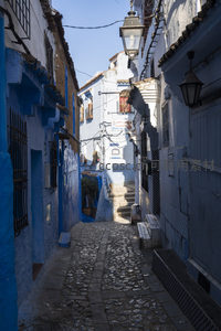 阳光洒落的蓝色街巷，传统灯笼与石板路相映成趣