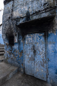 斑驳蓝墙与旧门扉