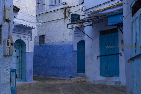 蓝白小镇街角，酒店招牌与木门点缀宁静时光