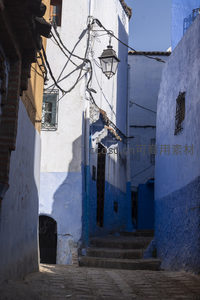 光影交错的蓝色小巷，老式街灯映衬岁月痕迹