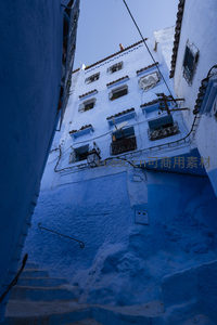 仰望蓝白建筑，窗棂错落如童话世界