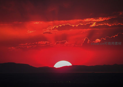 血色残阳沉落山峦，云霞如火染天际