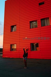 红墙前少女飞扬秀发享受夕阳余晖