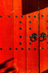 阳光下朱红古门铜环特写