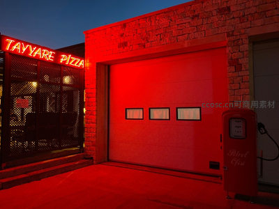 霓虹灯照亮的披萨店外景与复古加油泵