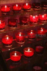 多层玻璃架上燃烧的红色蜡烛
