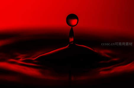 红色背景下水滴溅起瞬间