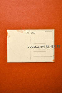 复古明信片静置在温暖橙色纸面上