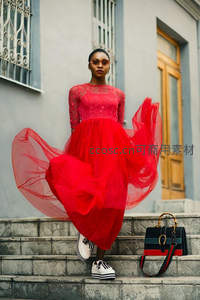 红裙女子在石阶上优雅摆动裙摆