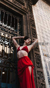 红裙女子倚古建筑雕花窗棂