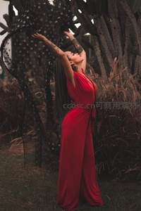 红裙女子在仙人掌丛中伸展双臂