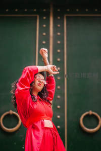 红衣女子在古门前优雅伸展