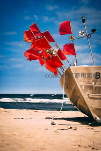 沙滩上停泊的小船与飘扬的红旗