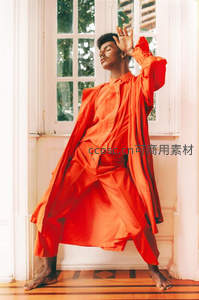 身着红色长袍的舞者在窗边起舞