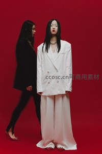 红幕前白衣模特与黑衣行人构成时尚对比