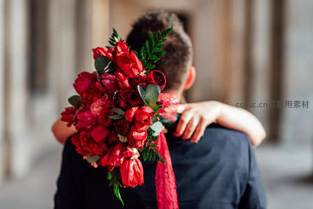 红玫瑰花束拥吻情侣背影