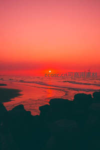 海边日落余晖，风车剪影映霞光