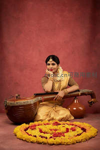 印度女子身着金纱丽，怀抱维纳琴花环环绕