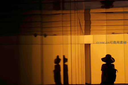 黄昏下玻璃幕墙的人影剪影