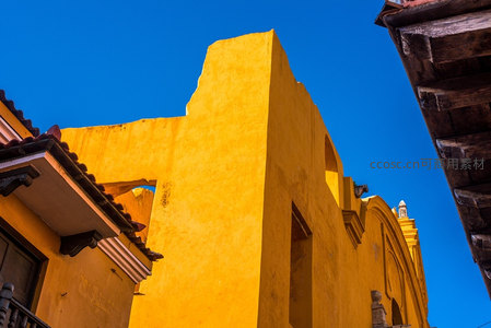 阳光下的明黄色古建筑，蓝天映衬显活力