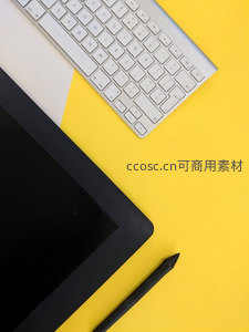 黄色桌面上键盘数位板笔构成创意工作区