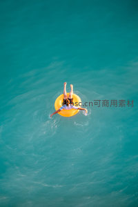 航拍视角下碧波中漂浮的橙色泳圈