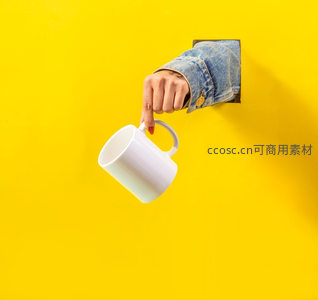 手从黄色墙洞递出白色马克杯创意